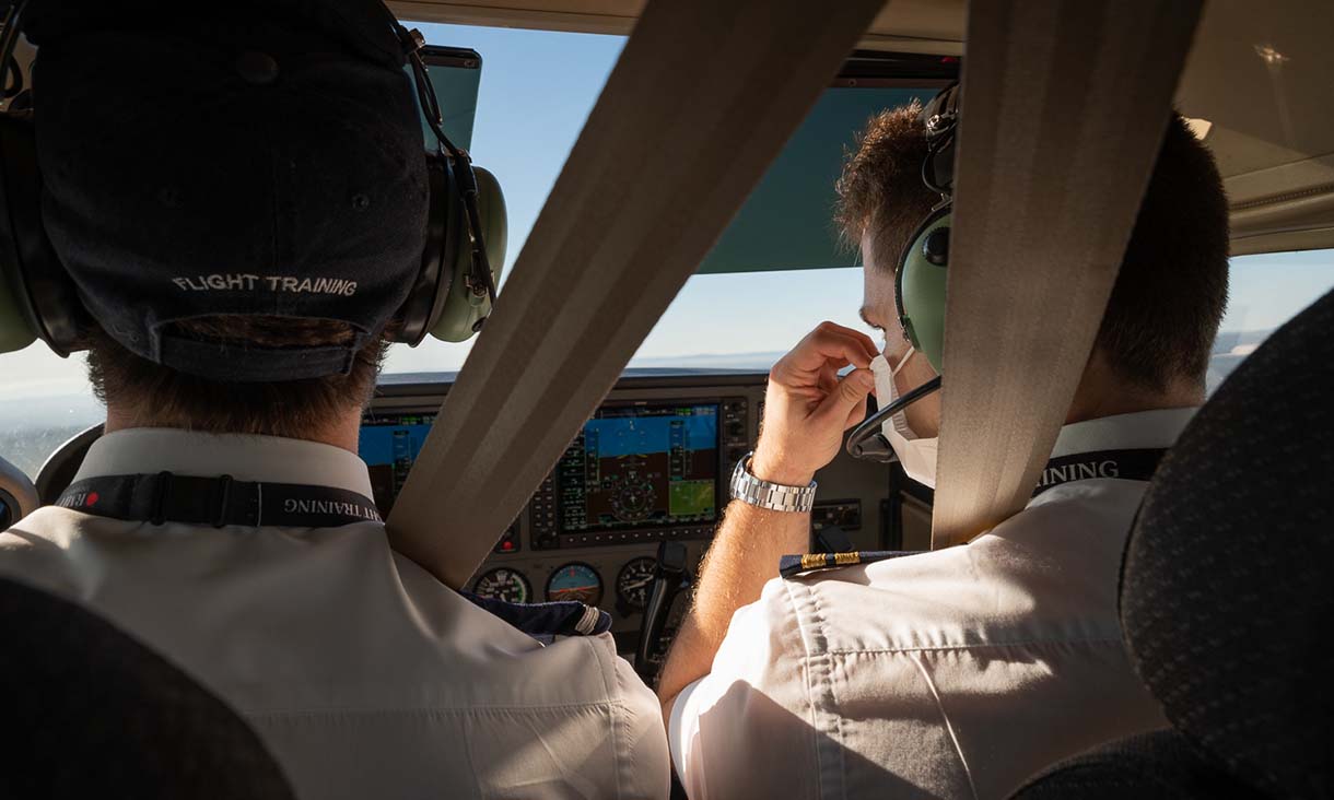 Two Bachelor Aviation (Flight Training) students in the cockpit of a plane, operating a plane