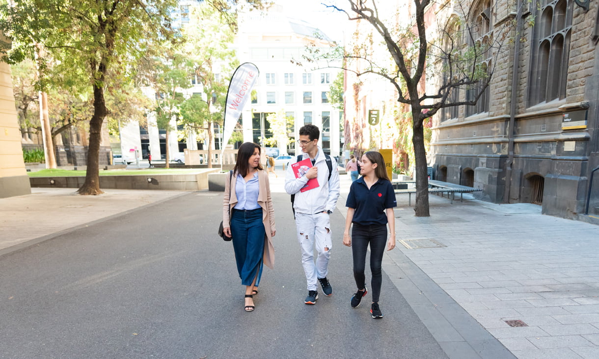 Future student and parent walking with an RMIT ambassador