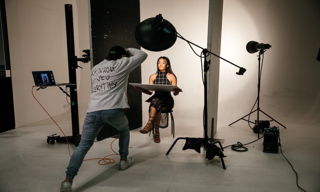 Female model having photos taken in a profesionally lit studio space