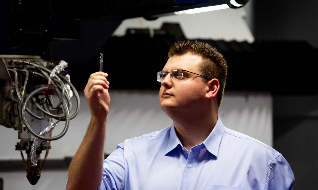 PhD student Jimmy Toton inspects a 3D-printed steel tool.