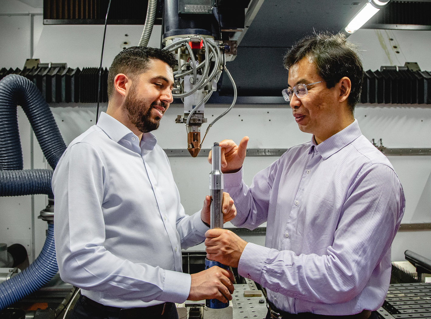 Carmelo Todaro and Ma Qian inspect a 3D printed Titanium alloy cube on the tip of an ultrasound rod.