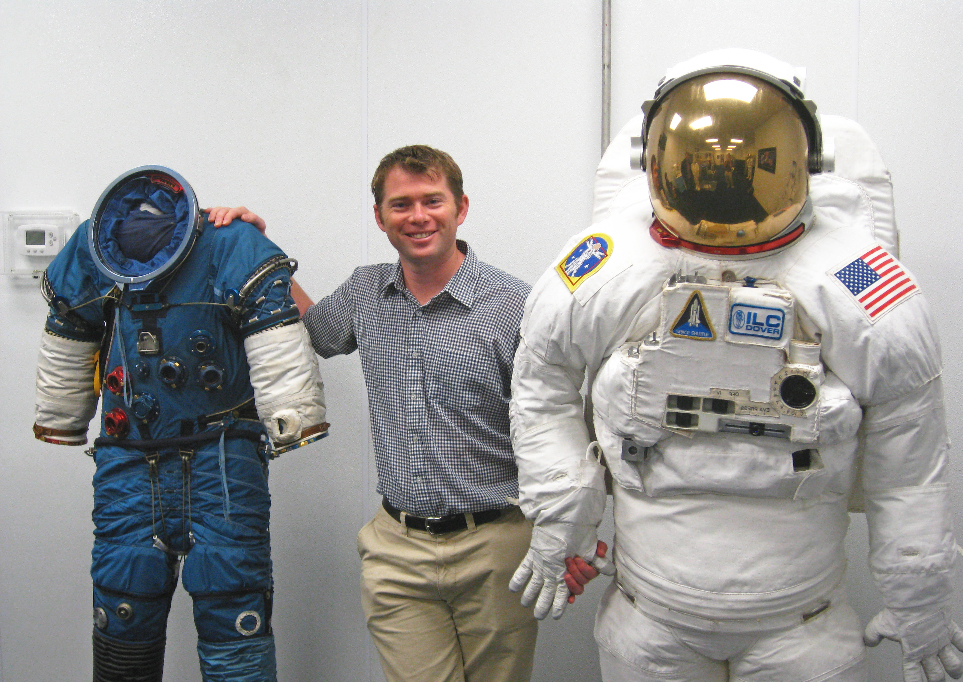 RMIT alumnus and Chief Engineer at Human Aerospace, Dr James Waldie, poses with NASA Extravehicular Activity suits used for spacewalking.