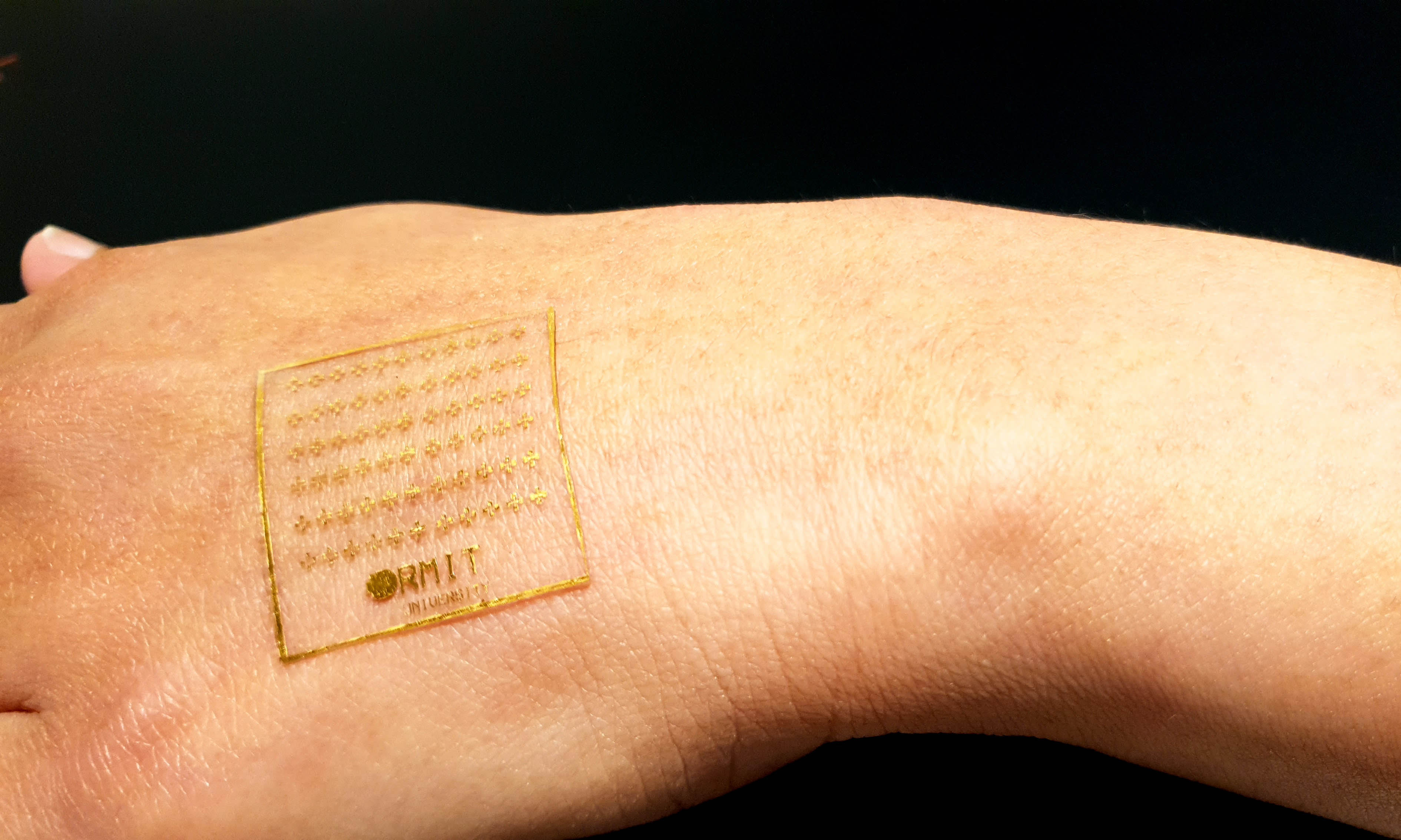 Clear stretchable electronic device on the back of a hand.