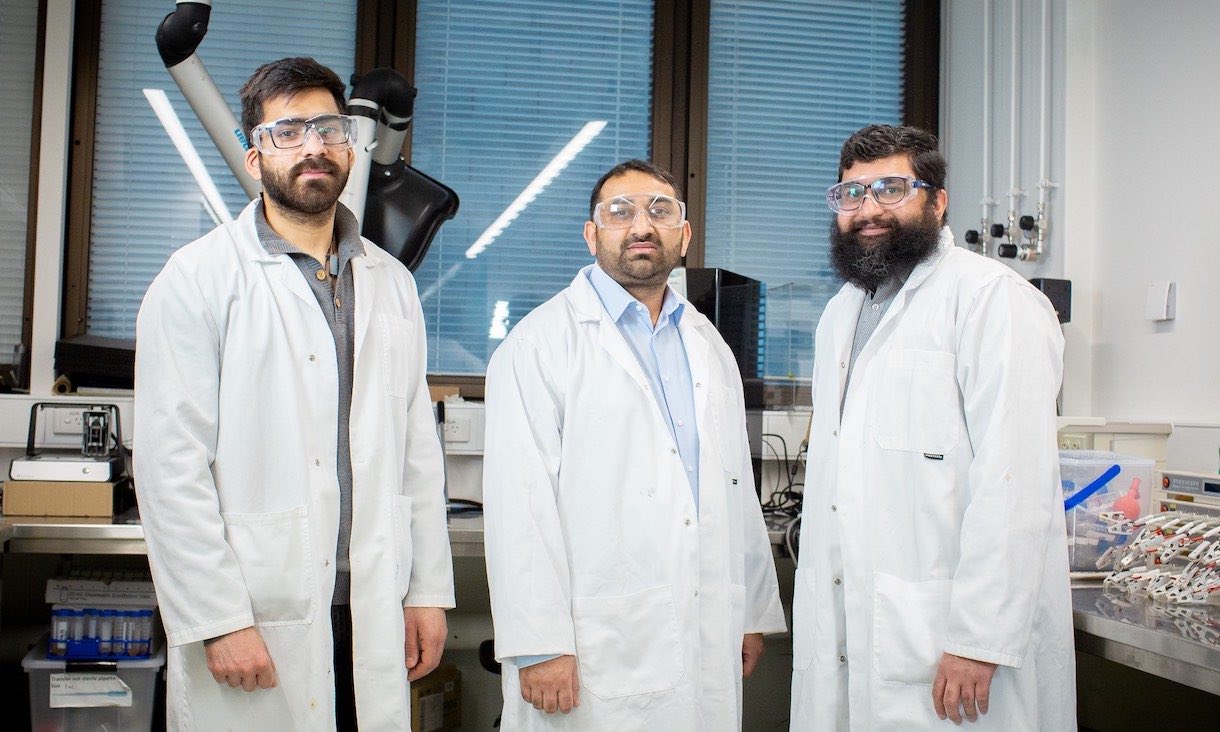 three members of the seawater hydrogen research team wearing lab coats in a laboratory