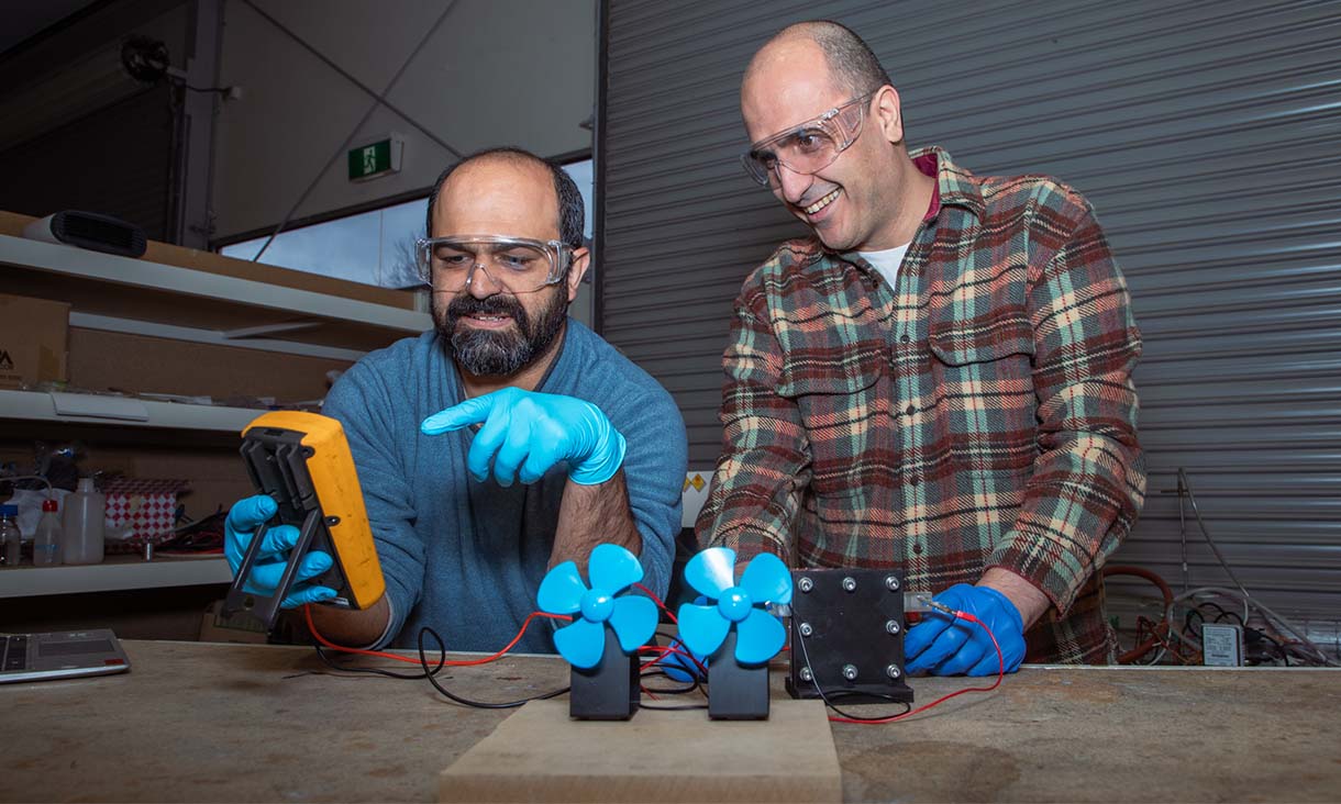 Dr Shahin Heidari (left) and Dr Seyed Niya with the proton battery operating two small fans in the RMIT lab. Credit: RMIT University