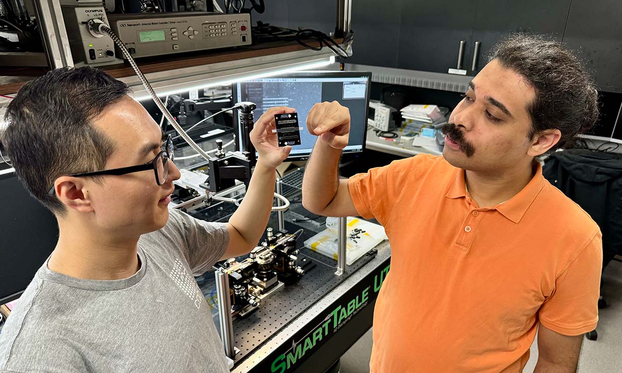 PhD scholar Yang Yang (left) and Dr Akram Youssry from RMIT with the team’s reprogrammable light-based processor. Credit: Will Wright, RMIT University