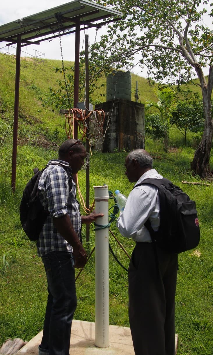 RMIT academic Jega Jegatheesan inspects a borehole with a local community member.  