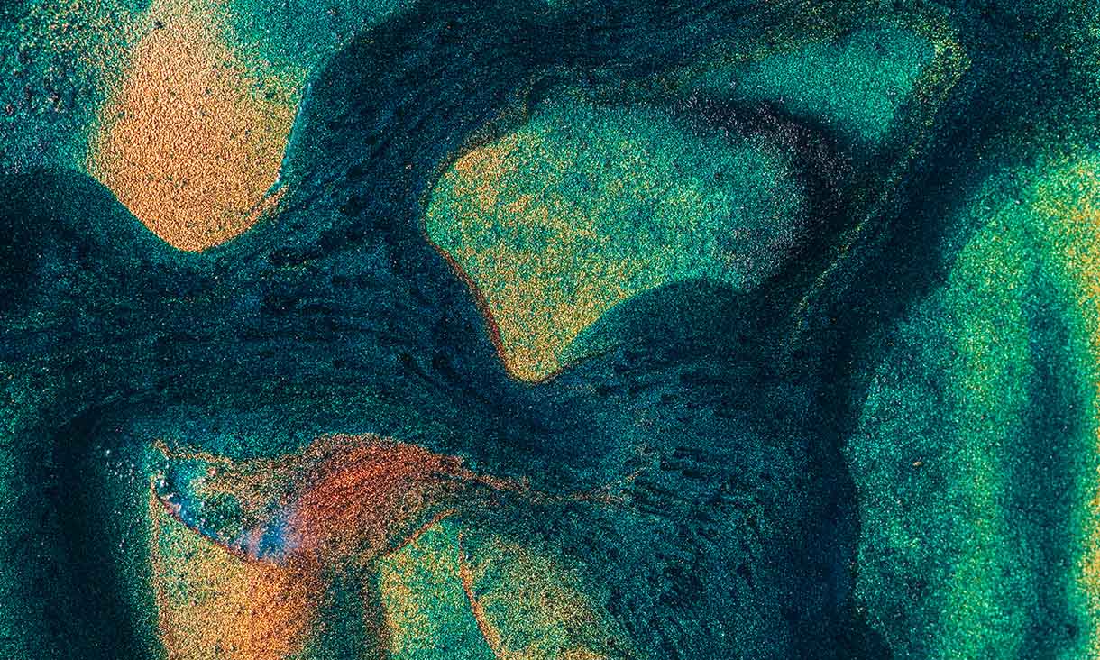 Abstract close-up of colourful green and orange chemical textures, symbolising sustainable chemistry.