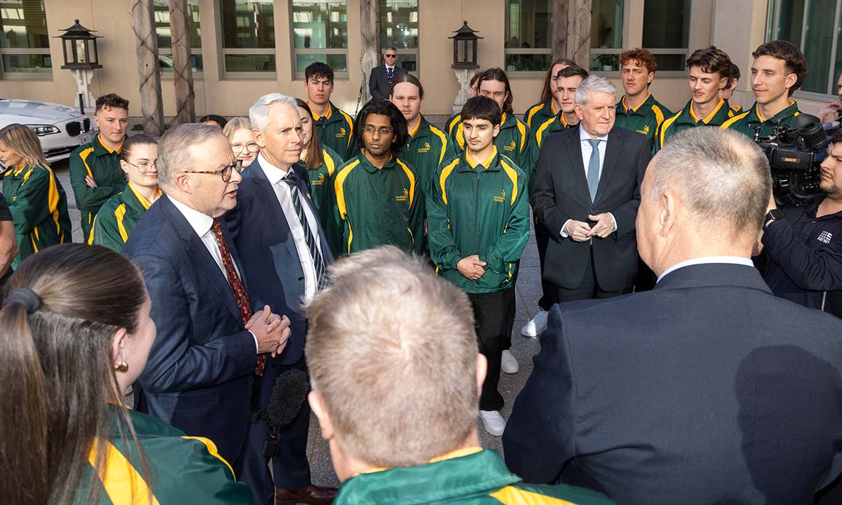 WorldSkills students in green and yellow uniforms listening to Anthony Albanese in suits during an outdoor event, with media present.