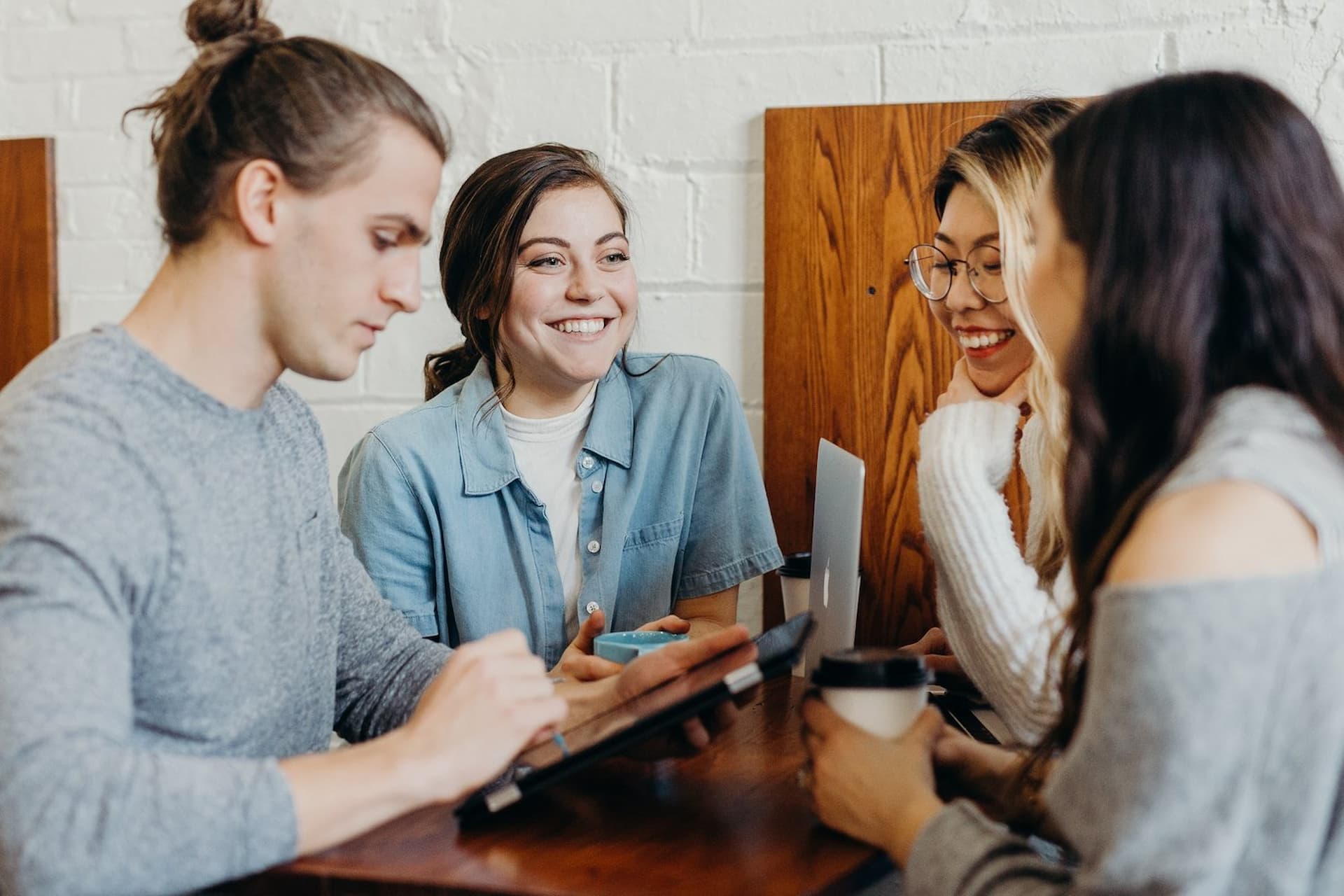Group of friends talking with coffee and laptops