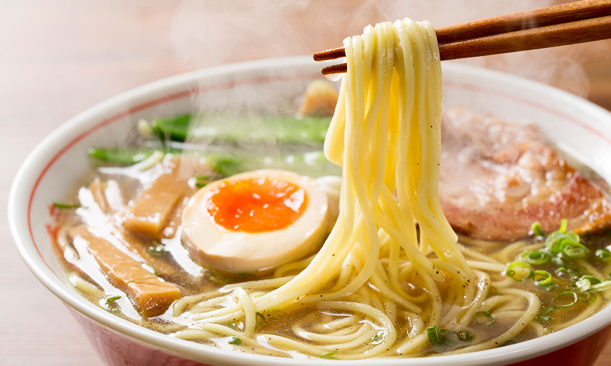 熱々の醤油ラーメンを箸で摘む