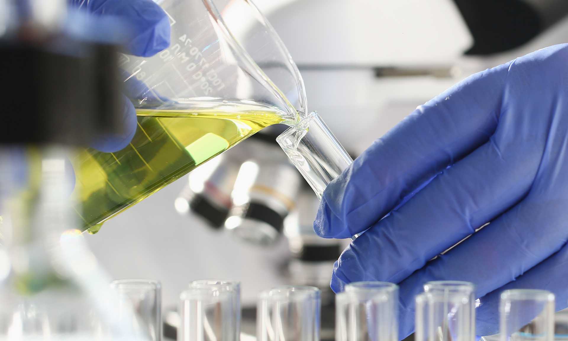A chemist holds test tube of glass in their hand