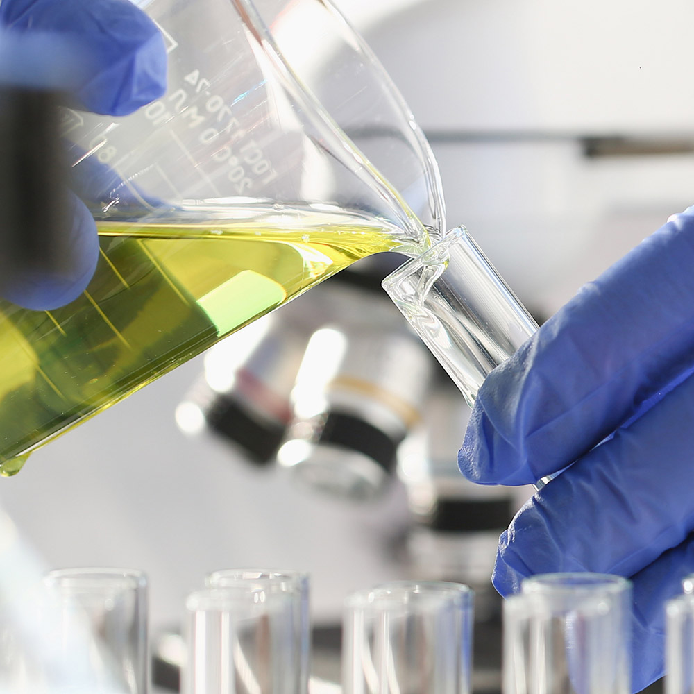 A chemist holds test tube of glass in their hand