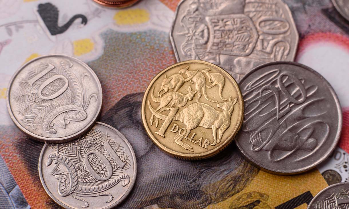 Various Australian dollar coins displayed on a banknote, illustrating the denominations and currency style.