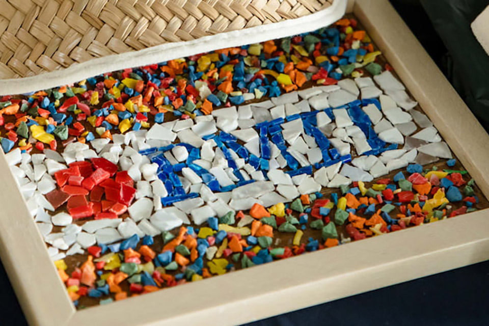 A mosaic of the letters RMIT with a coloured banner above and below it
