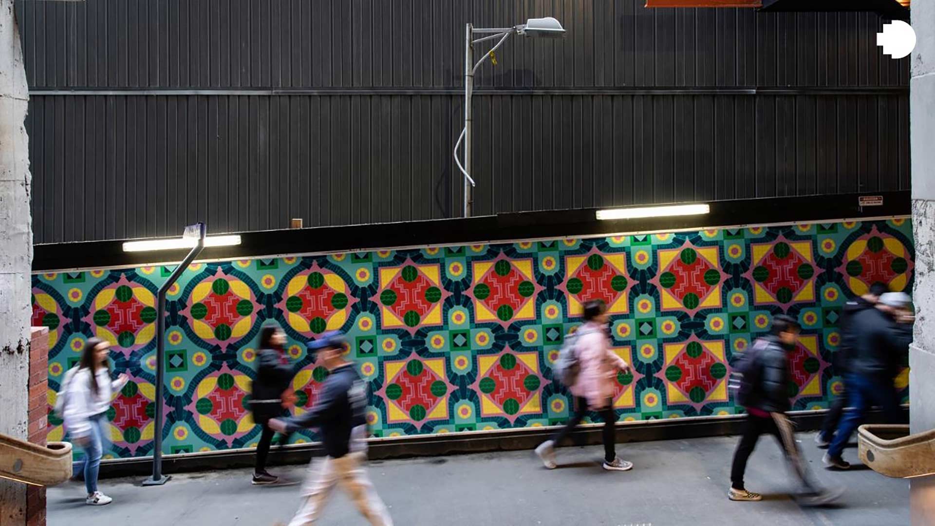 People walking past a Metro Tunnel street mural