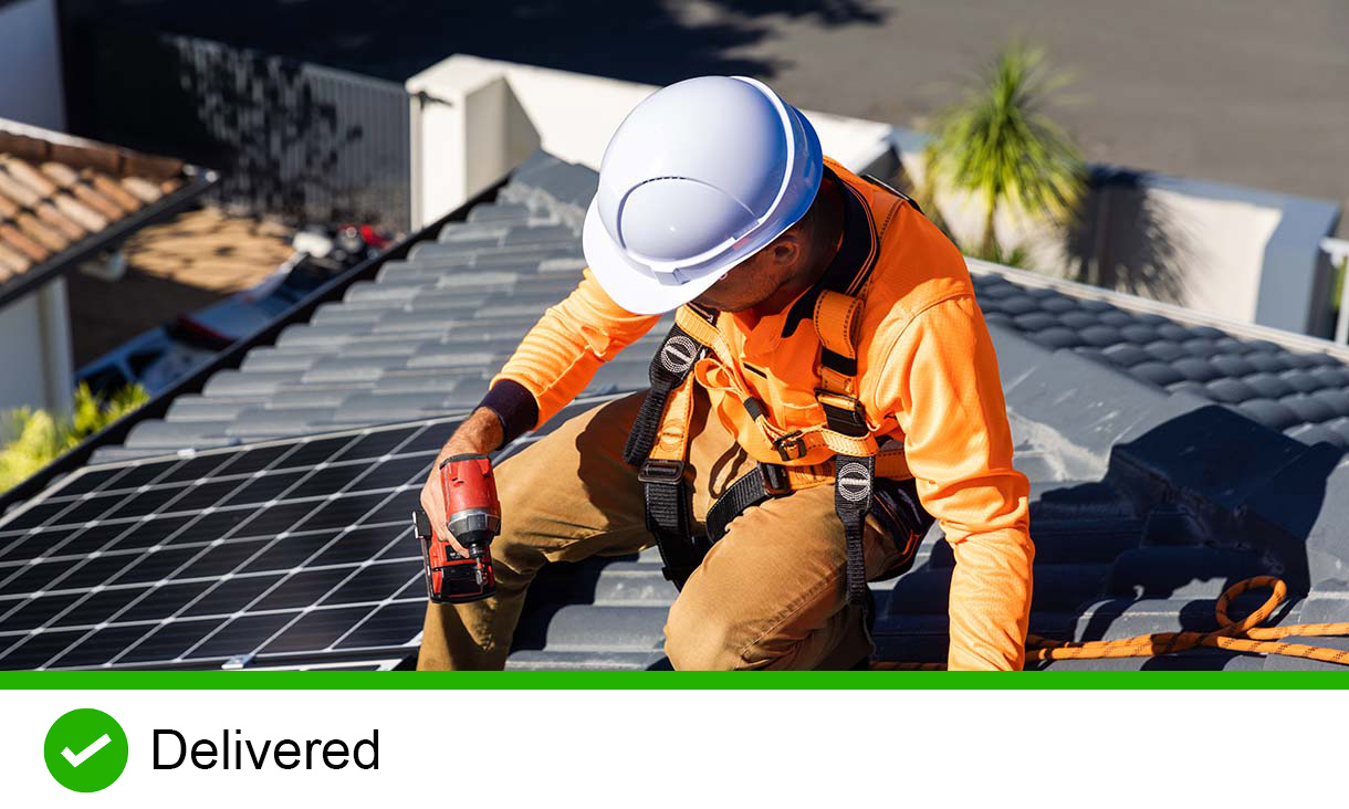 Worker installing solar panel on roof