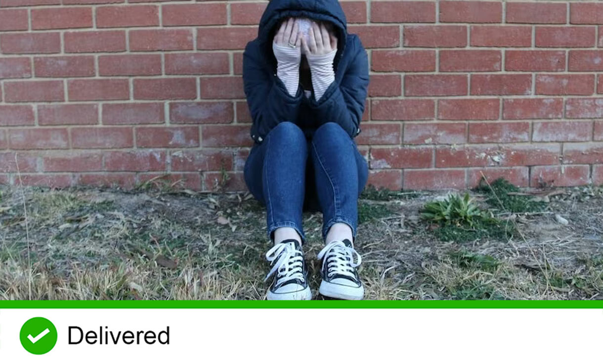 Person with head in hands sitting on ground