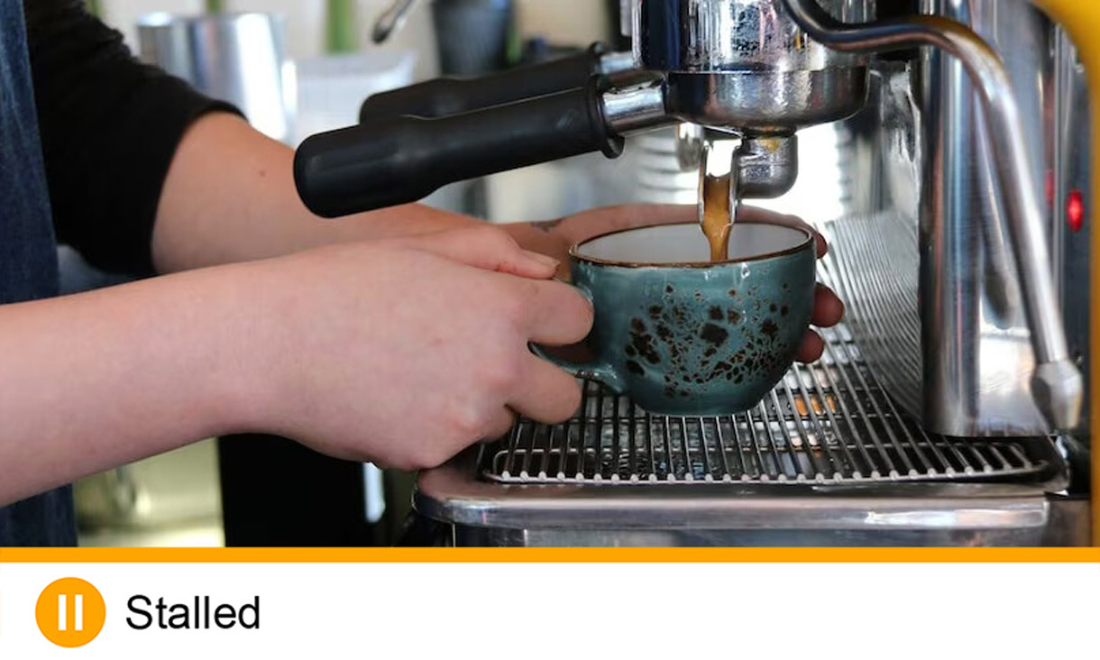 Hands operating coffee machine