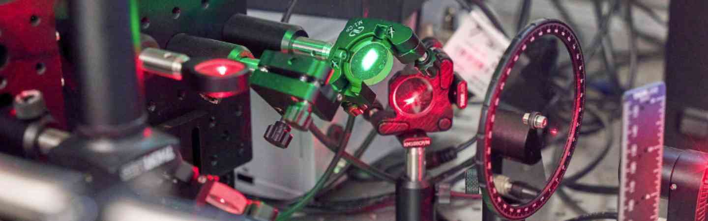 Photograph of a piece of mechanical machinery. It has red and green lighting.