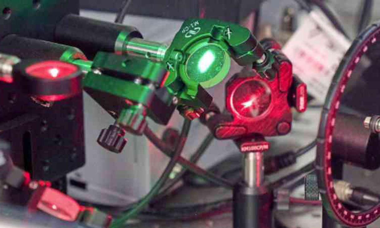 Photograph of a piece of mechanical machinery. It has red and green lighting.