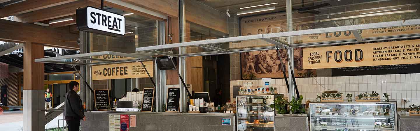 Person standing at front of Streat cafe on campus