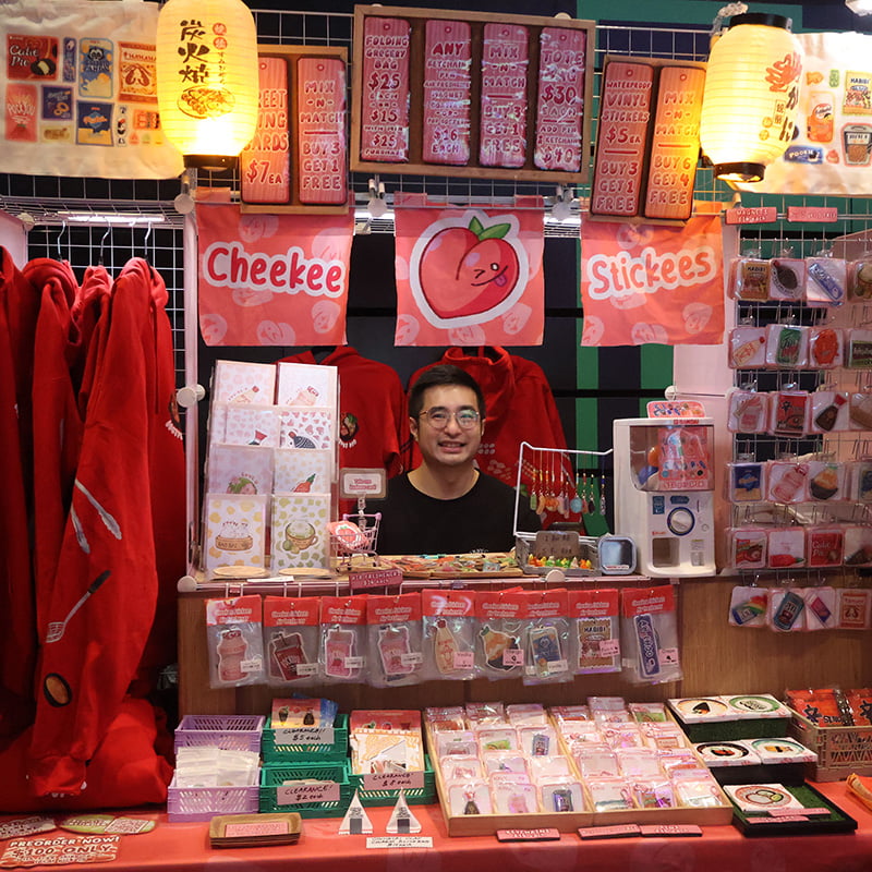 Portrait of Mark Tan in a booth surrounded by his work