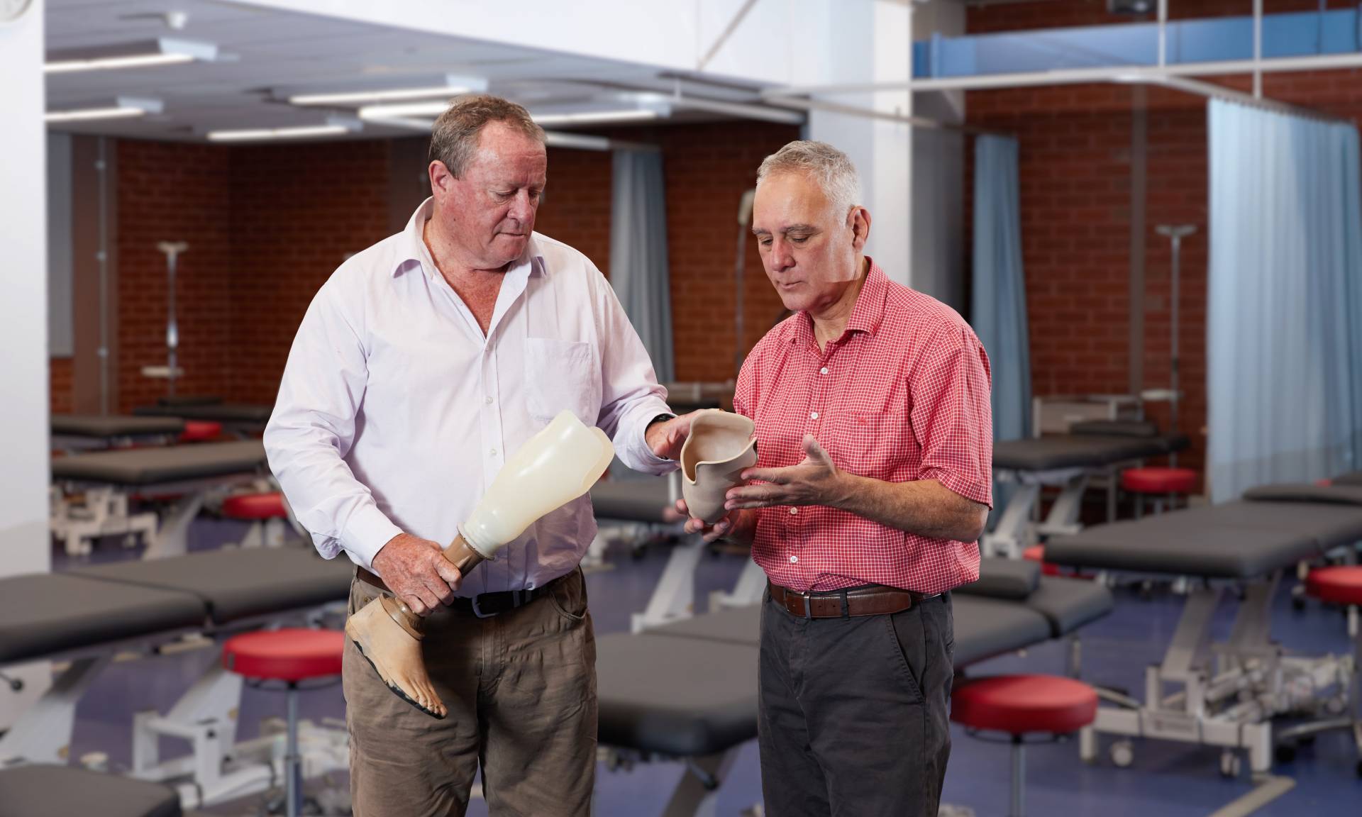 An image of two people holding prosthetic legs.