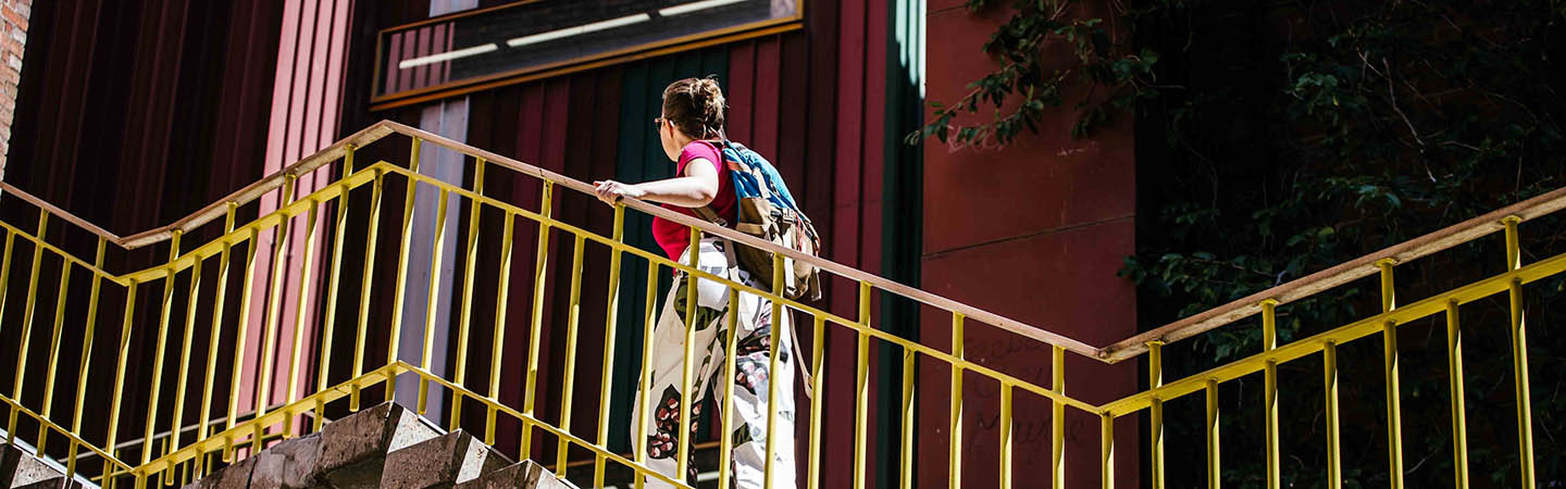 female student walking up stairs on campus