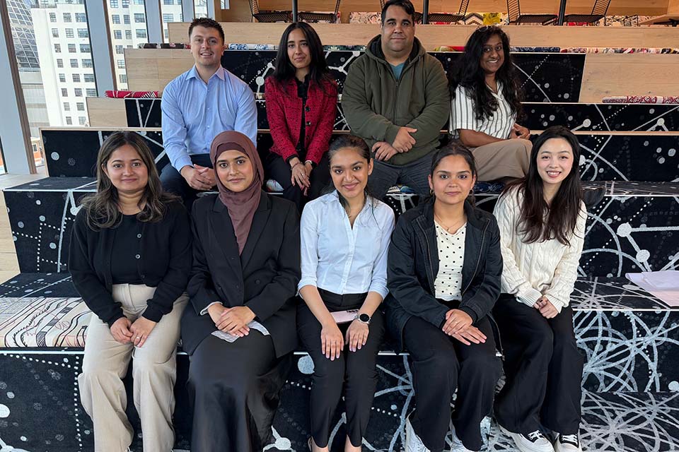 Group of people sitting together smiling at the camera.