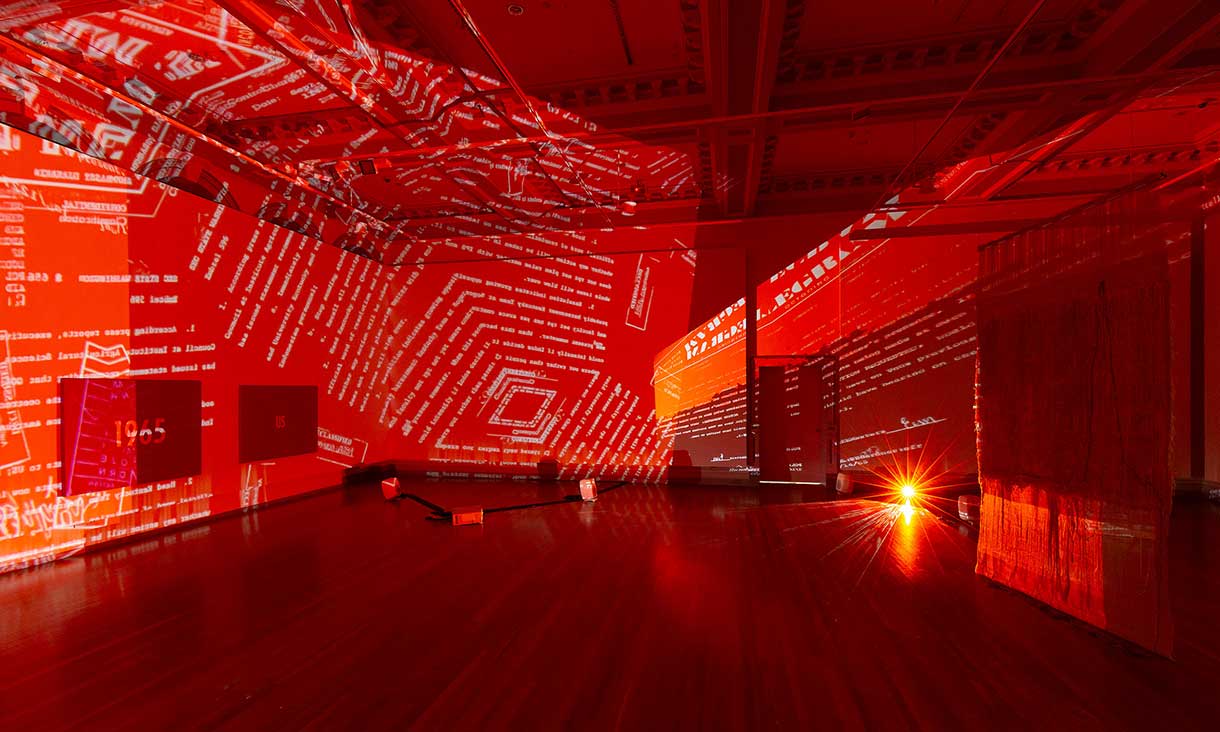 Installation view, Tintin Wulia, December 2021 (projection), Absence in Substantia: Density 2023 (on right) and Subtext – after Kawara’s Title, 1965 2019 (on wall), in Tintin Wulia: Secrets, RMIT Gallery, Melbourne, 2023. 
