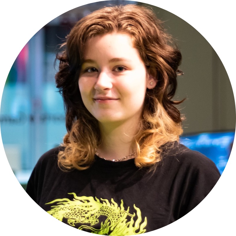 smiling student with long hair and dragon t-shirt