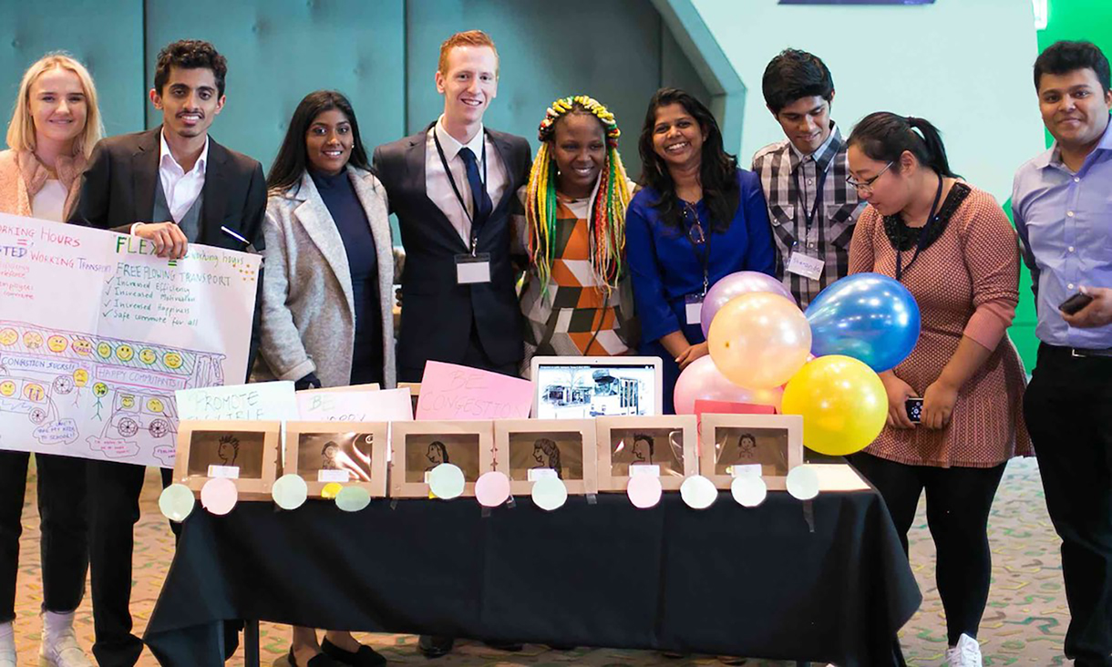 Students at the Global Leader Experience event stand in a row and pose for a photo.