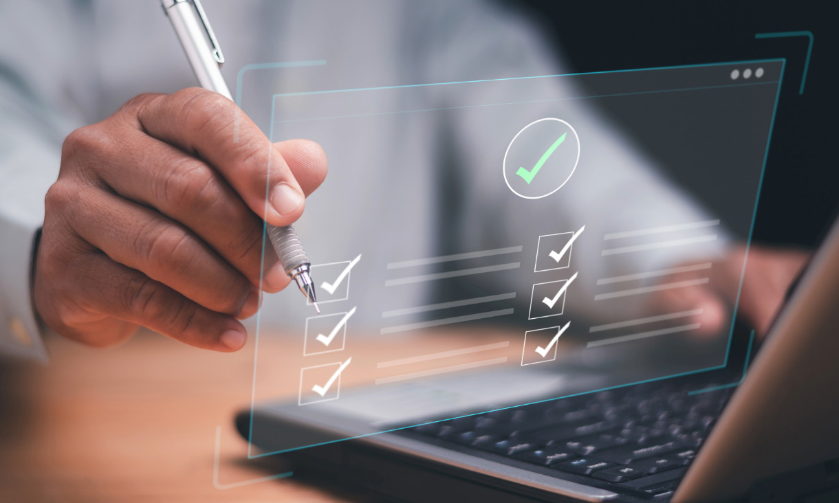 Person writes on hollogram of screen in front of laptop