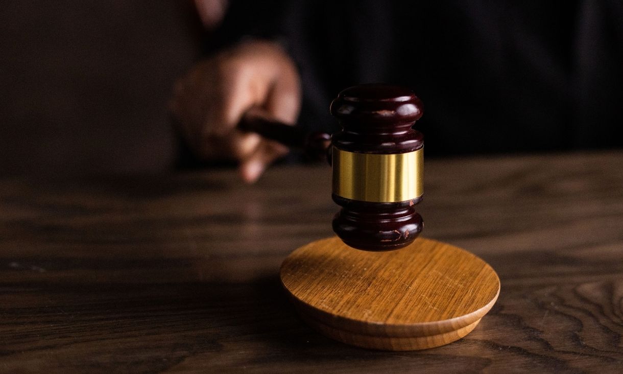 A gavel striking a sound block, symbolizing justice and legal authority in a courtroom setting.