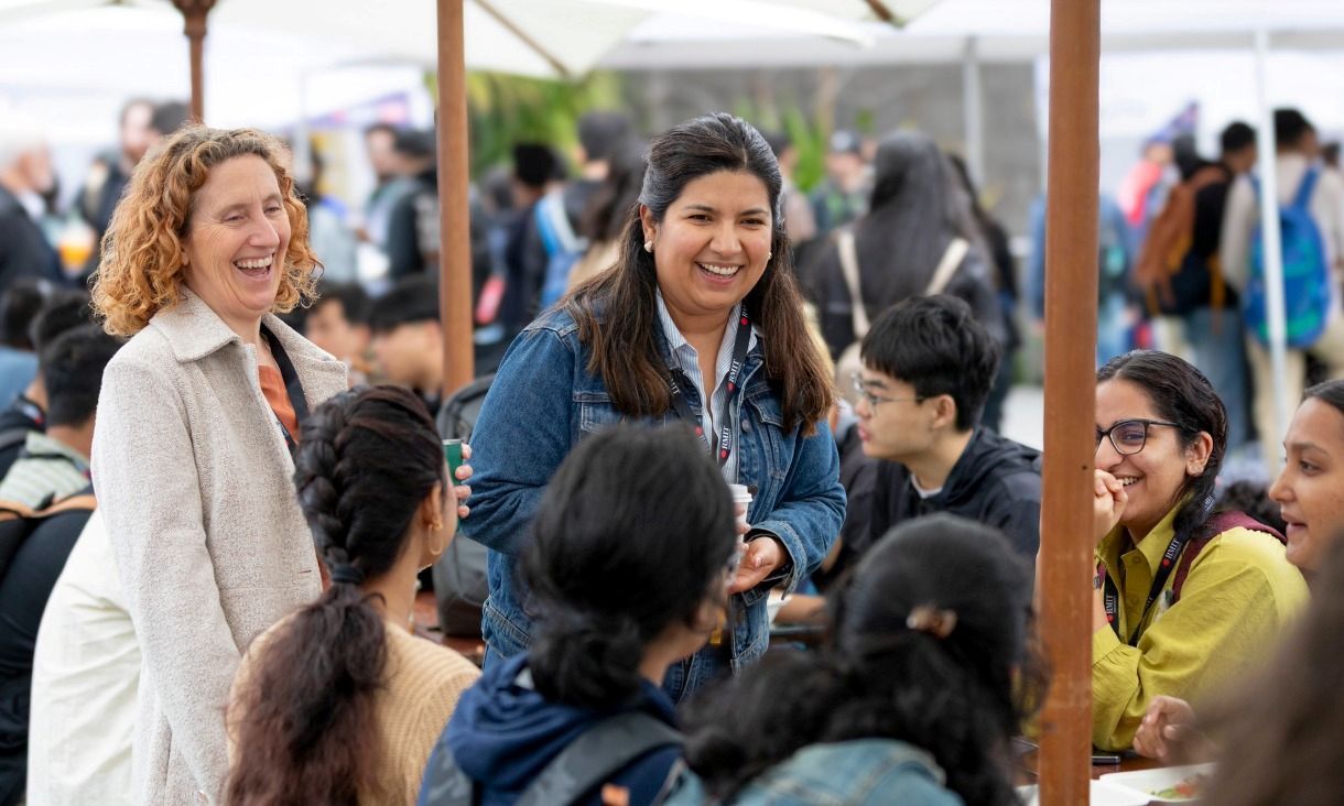 two RMIT staff members smiling in a crowd
