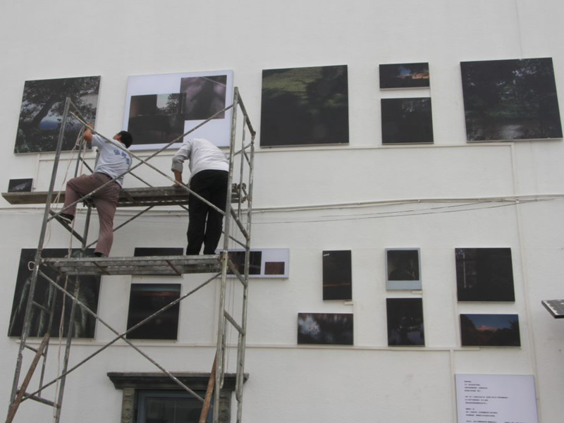 Two people on scaffolding outside building