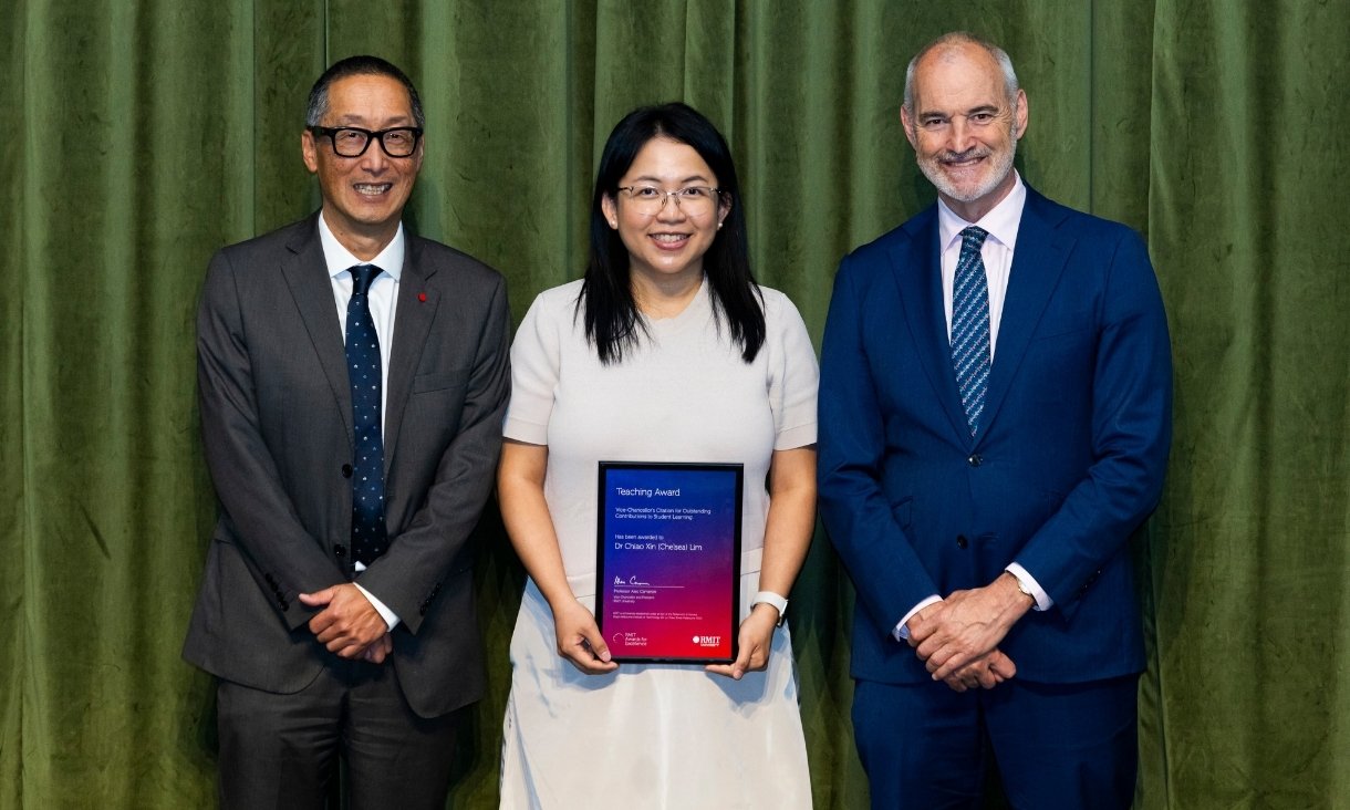 Three people posing in front of curtain