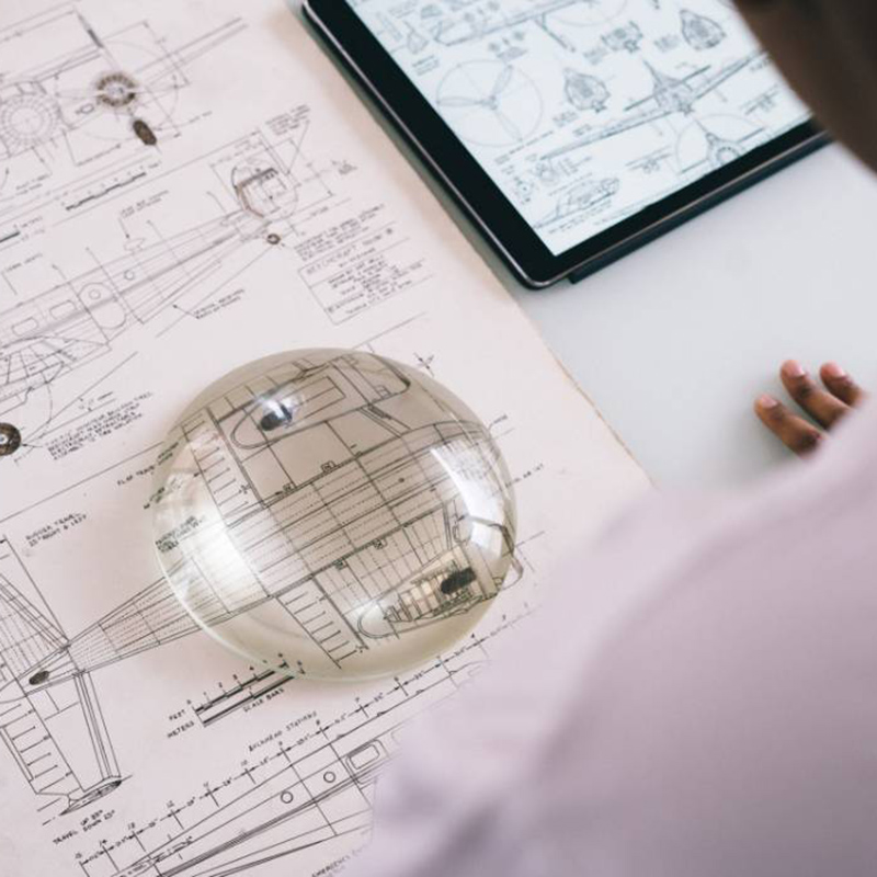 Blueprints with a magnifying glass over them