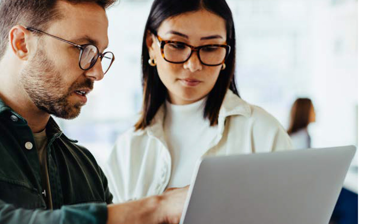 The cover of the Building workforce capability pdf showing two people pointing at a laptop