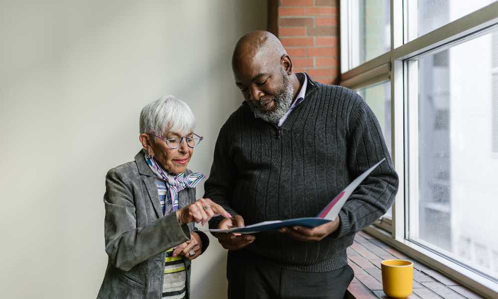 Two people both looking at a file document
