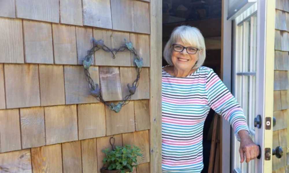 Elderly person opening front door of house