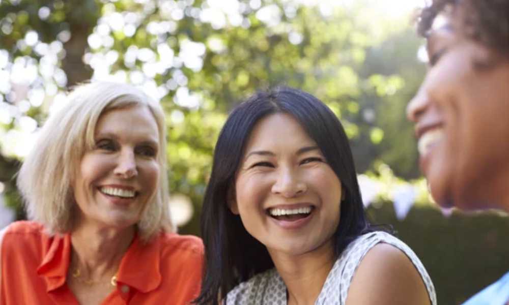Three people laughing together outside
