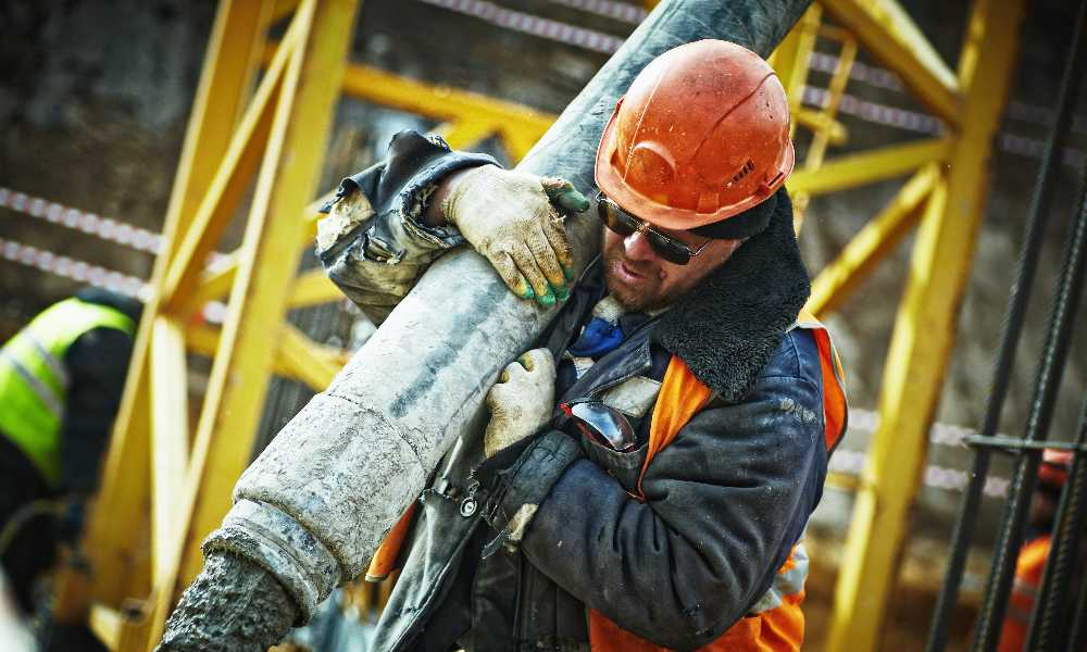 Construction worker carrying a giant pin