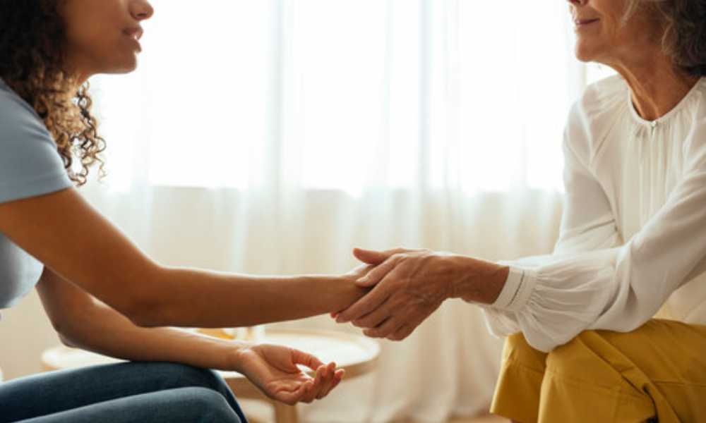 Person holding another person's hand in support