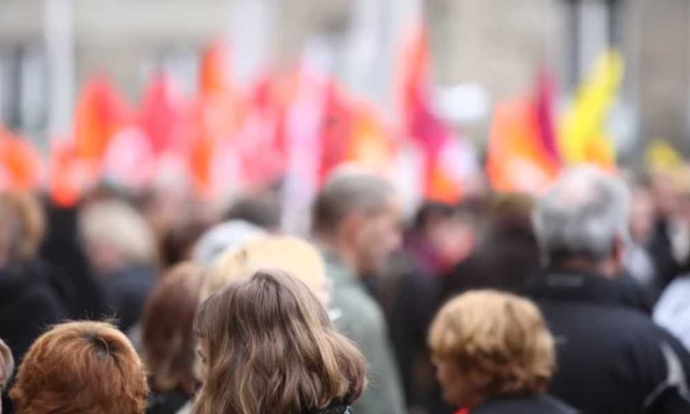 Blurred out crowd from back carrying banners