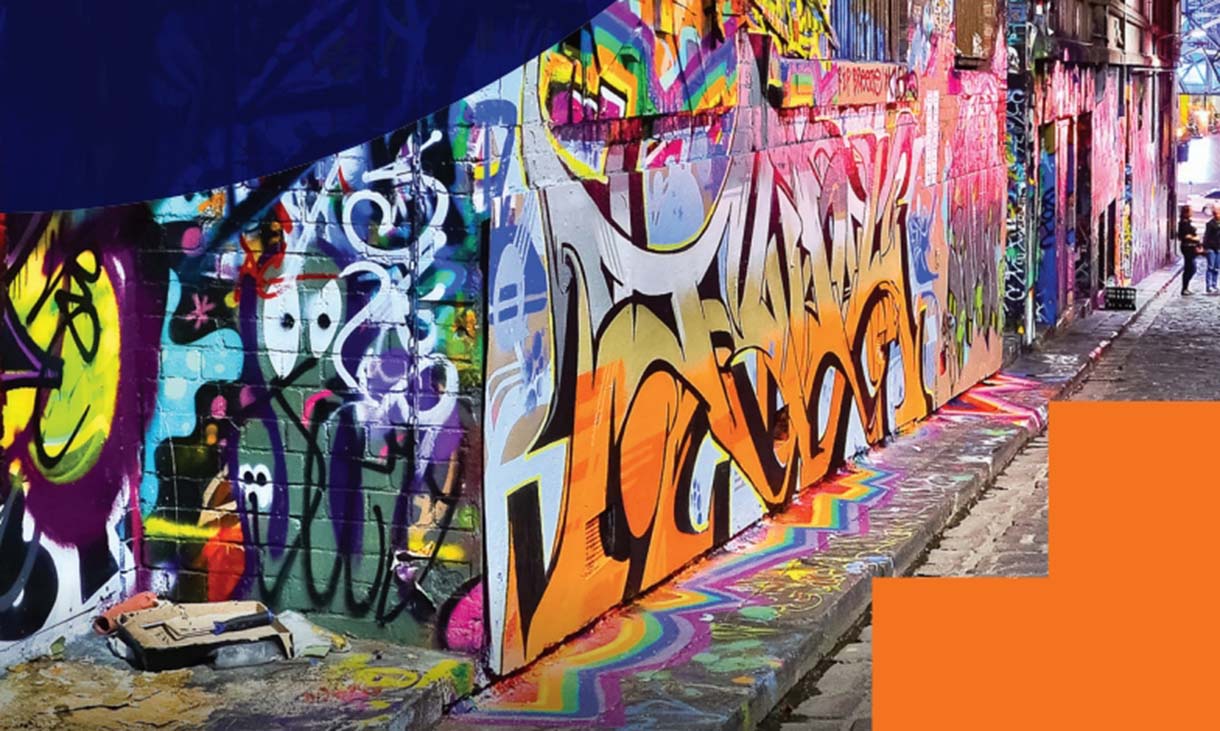 A colorful graffiti-covered laneway in Melbourne, with vibrant street art on brick walls and a cobblestone path.