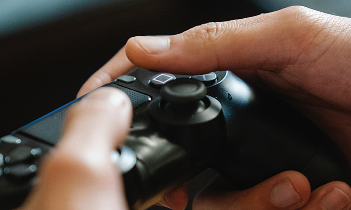 Hands holding a video game console controller.