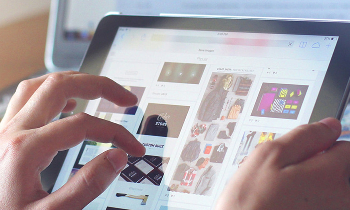 Hands holding a tablet scrolling through shopping options.