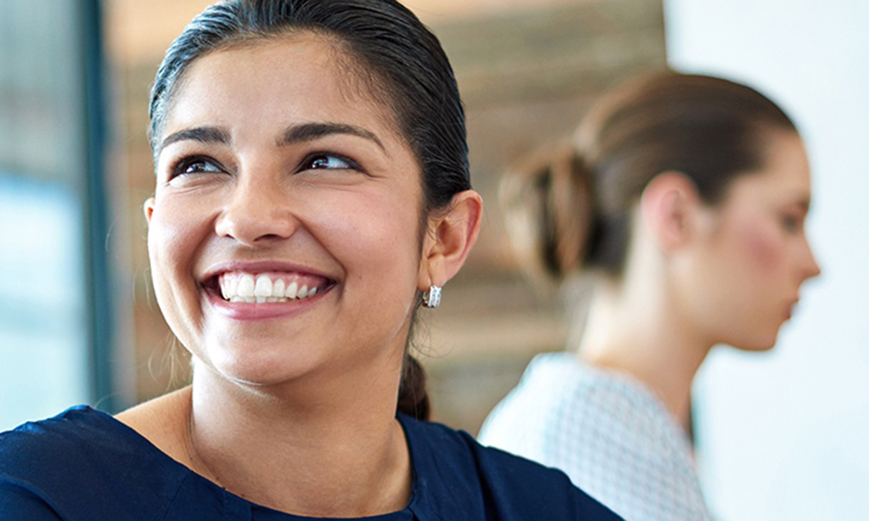 Woman smiling brightly in conversation.